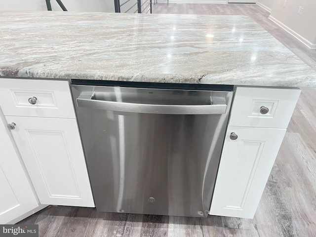 details featuring dishwasher, wood-type flooring, white cabinets, and light stone counters