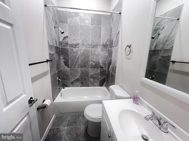 full bathroom featuring vanity, tiled shower / bath combo, and toilet