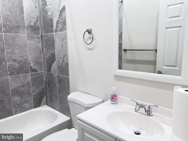 full bathroom featuring tiled shower / bath, vanity, and toilet