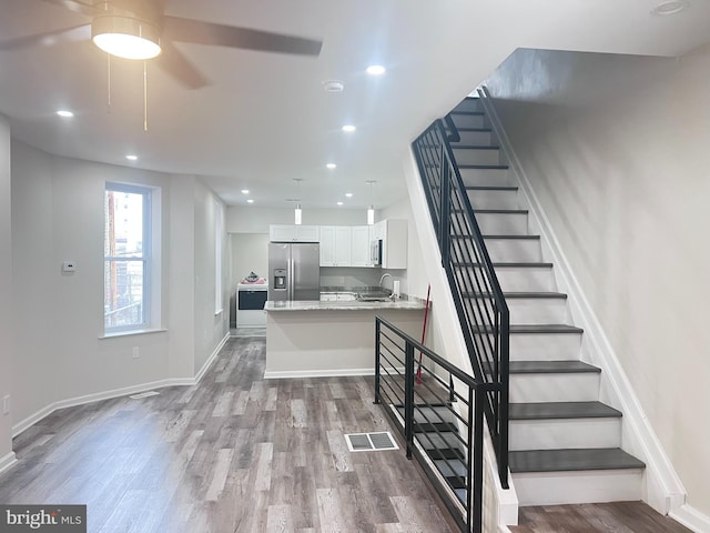 stairs with sink and hardwood / wood-style floors