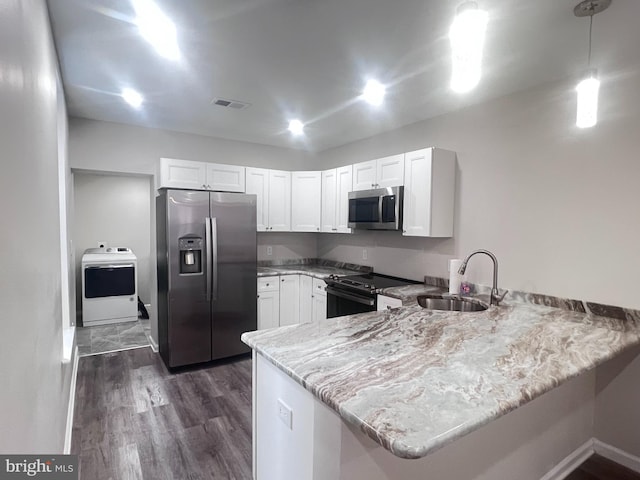 kitchen featuring stainless steel appliances, washer / dryer, sink, and kitchen peninsula