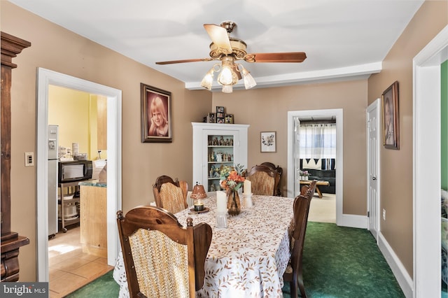 dining area with dark carpet and ceiling fan