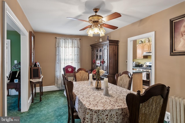 carpeted dining space featuring radiator and ceiling fan