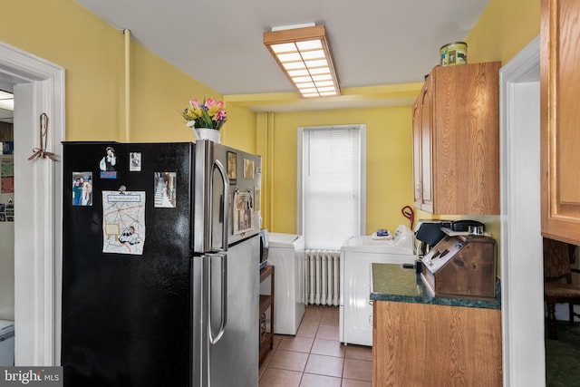 kitchen featuring light tile patterned floors, stainless steel fridge, and radiator heating unit