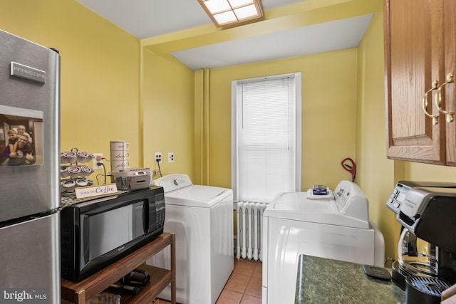 laundry room featuring light tile patterned floors, radiator heating unit, and washer and dryer