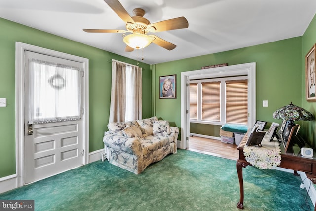 living area featuring carpet flooring and ceiling fan