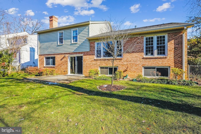 rear view of house featuring a patio area and a lawn