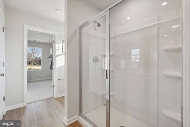 bathroom with an enclosed shower and hardwood / wood-style floors