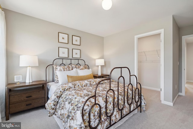 carpeted bedroom featuring a walk in closet and a closet