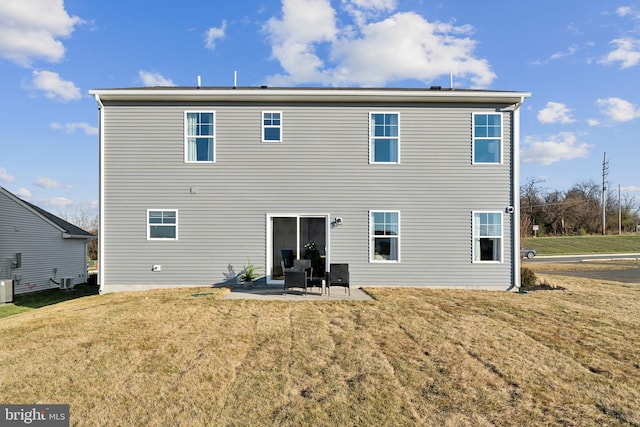 rear view of house with central AC unit, a patio area, and a lawn