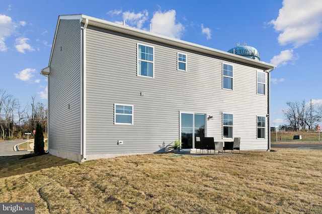 rear view of property featuring a patio area and a lawn