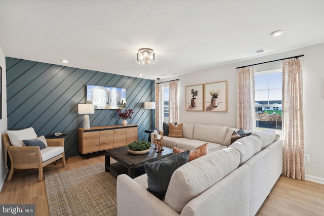 living room with wooden walls and light wood-type flooring