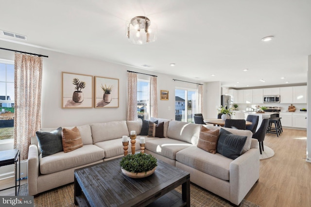 living room featuring a chandelier and light wood-type flooring