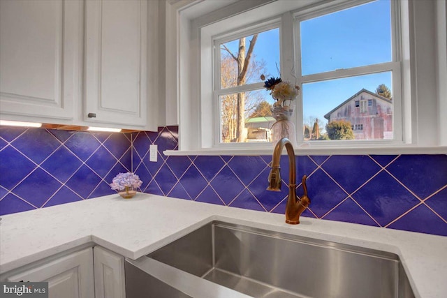 kitchen with white cabinetry, sink, and decorative backsplash