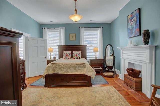 bedroom featuring multiple windows and light hardwood / wood-style flooring