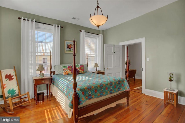 bedroom with multiple windows and wood-type flooring