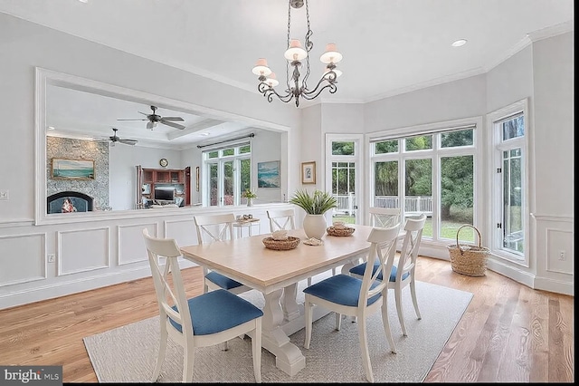 dining room featuring a healthy amount of sunlight, ornamental molding, and light wood-type flooring