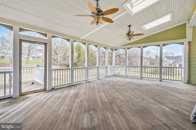 unfurnished sunroom with ceiling fan and lofted ceiling with skylight