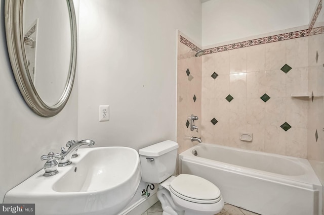 full bathroom featuring sink, tiled shower / bath combo, and toilet