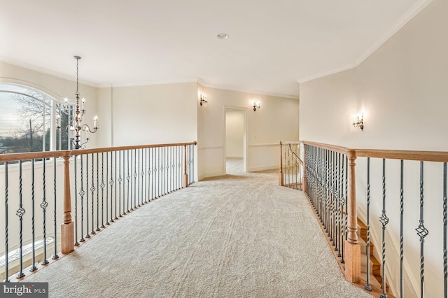 corridor with a notable chandelier, ornamental molding, and light colored carpet