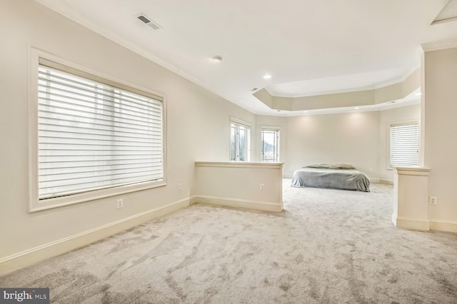 unfurnished bedroom with a raised ceiling, crown molding, and light colored carpet