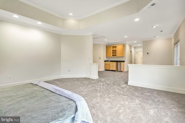 carpeted bedroom with ensuite bath, ornamental molding, and sink