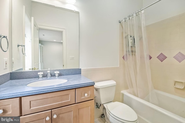 full bathroom with toilet, vanity, shower / bathtub combination with curtain, and tile walls