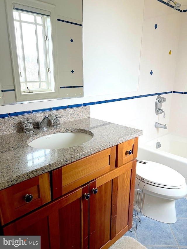 bathroom featuring vanity, toilet, tile patterned flooring, and a bathtub