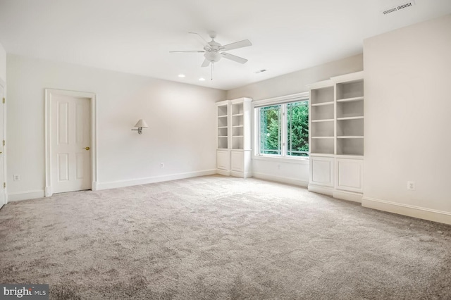 carpeted spare room featuring ceiling fan