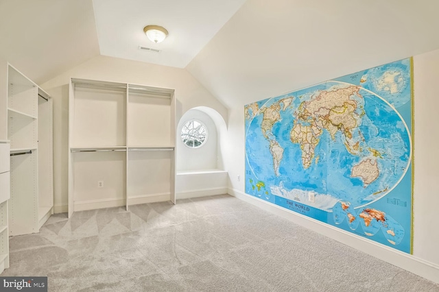 spacious closet featuring lofted ceiling and light carpet