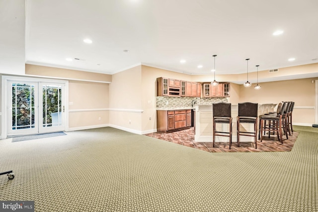 kitchen with hanging light fixtures, decorative backsplash, carpet floors, and a kitchen breakfast bar