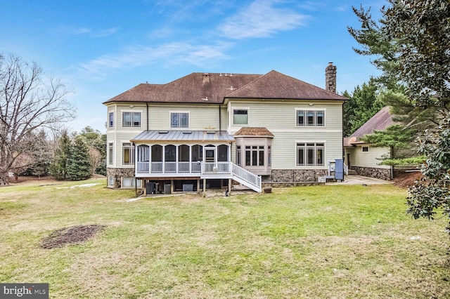 back of house featuring a yard and a sunroom