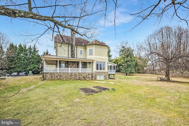 rear view of house with a sunroom and a lawn