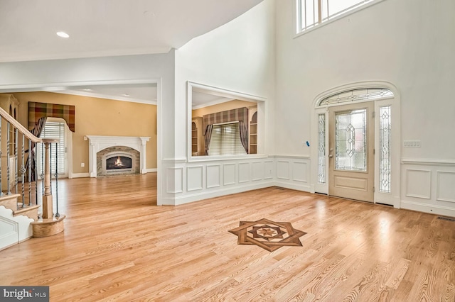 foyer featuring ornamental molding and light hardwood / wood-style flooring