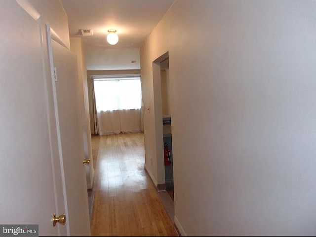 corridor with light hardwood / wood-style floors