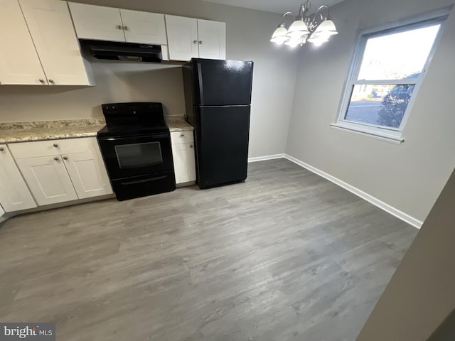 kitchen featuring white cabinetry, a chandelier, hanging light fixtures, black appliances, and light wood-type flooring