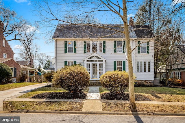 colonial home featuring central AC unit