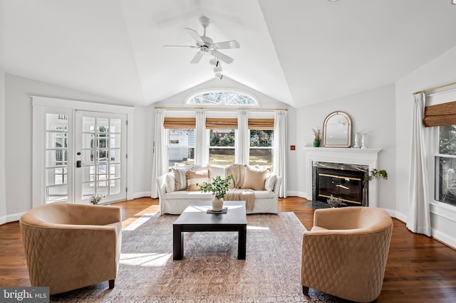 living area featuring lofted ceiling, a premium fireplace, ceiling fan, wood finished floors, and baseboards