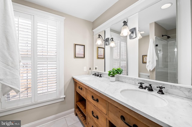 full bath with double vanity, a sink, toilet, and tile patterned floors