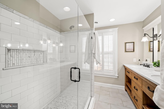 full bath featuring double vanity, baseboards, tile patterned flooring, a shower stall, and a sink