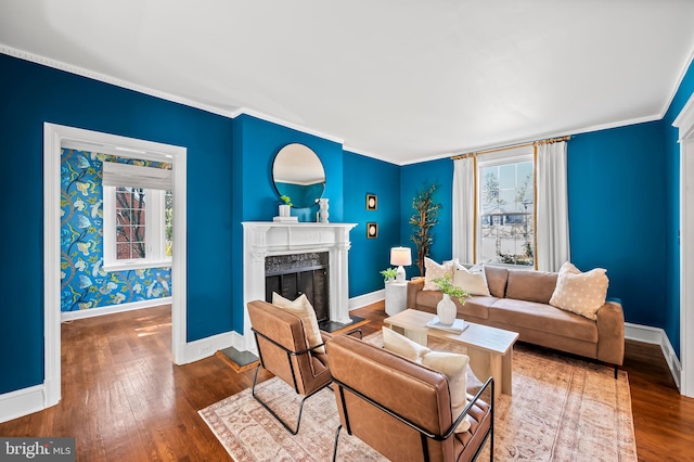 living room featuring wood-type flooring, baseboards, ornamental molding, and a high end fireplace