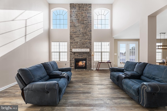 living room featuring a high ceiling, dark wood-type flooring, and a fireplace