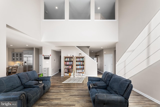 living room with hardwood / wood-style flooring and a high ceiling