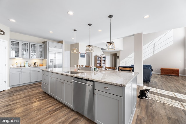 kitchen featuring an island with sink, stainless steel appliances, sink, and gray cabinetry