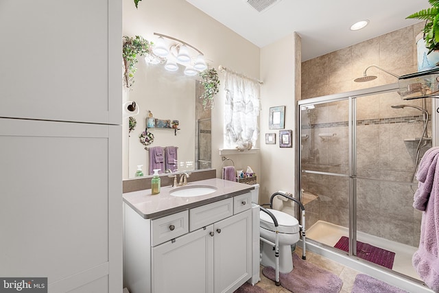 bathroom featuring vanity, tile patterned floors, a shower with door, and toilet