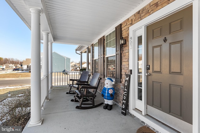 view of exterior entry featuring covered porch