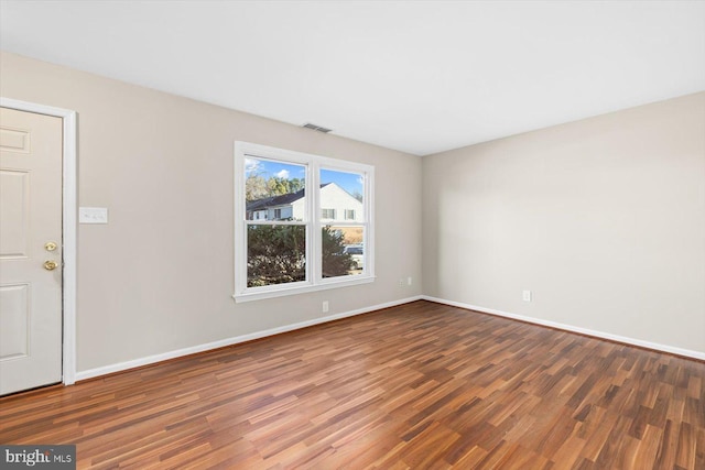 unfurnished room with dark hardwood / wood-style flooring