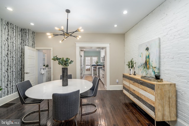 dining area with a notable chandelier and dark hardwood / wood-style floors