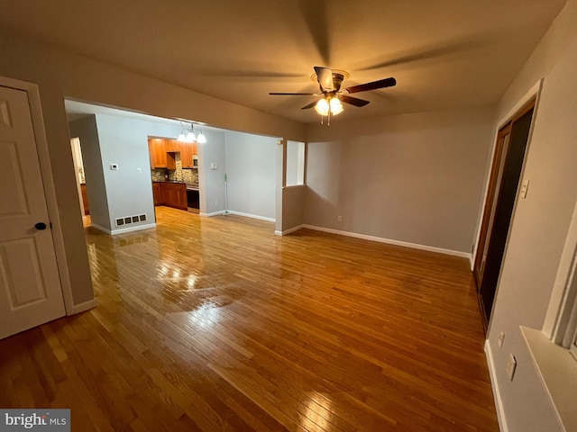 interior space featuring ceiling fan with notable chandelier and light wood-type flooring