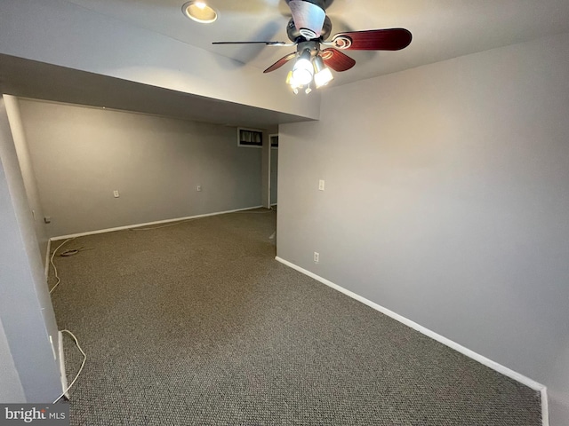 spare room with dark carpet and ceiling fan